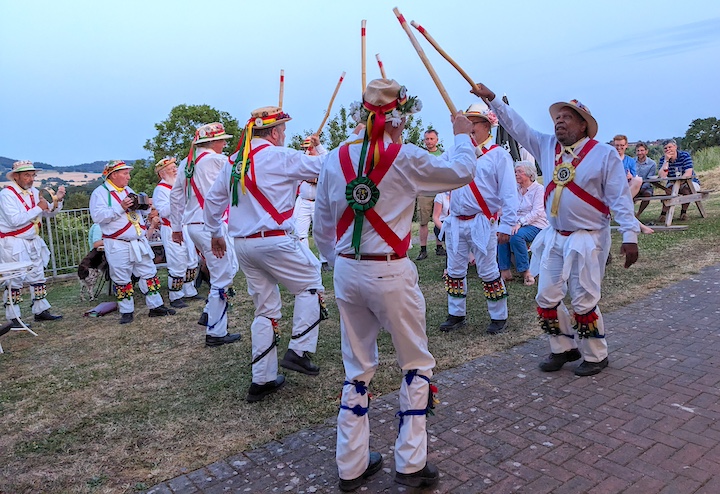 Musicians, and dancers with long sticks.